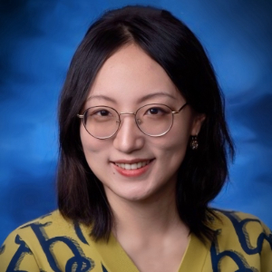 Smiling woman wearing glasses and a colorful cardigan