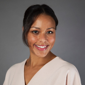 Smiling woman wearing a peach colored short-sleeved blouse