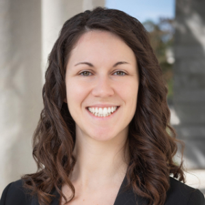 Smiling woman with brown hair wearing a black blazer