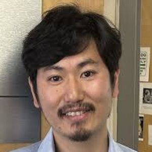 Smiling Asian man wearing a light blue button up shirt