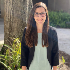 Smiling woman standing in front of a tree