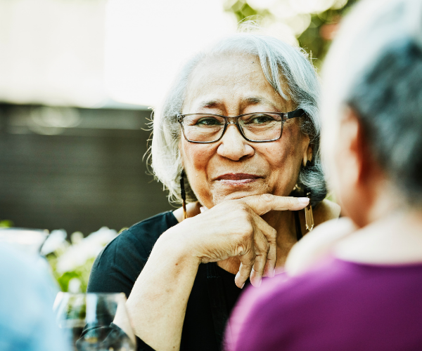 Senior woman smiling while sitting with a friend