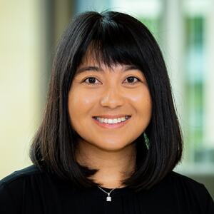 Smiling woman with bangs wearing a black sweater