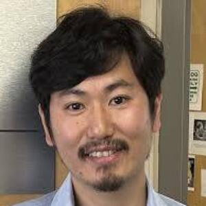 Smiling Asian man wearing a light blue button up shirt